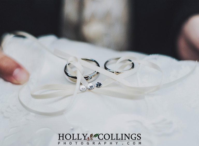 Photography of wedding rings on cushion before ceremony in St Petrox Church Dartmouth