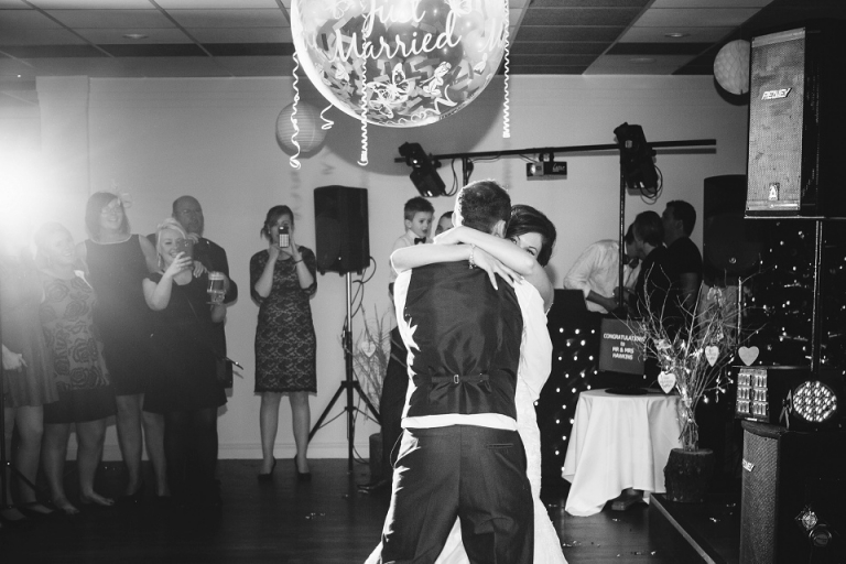 brides eyes smiling over shoulder of groom during first dance