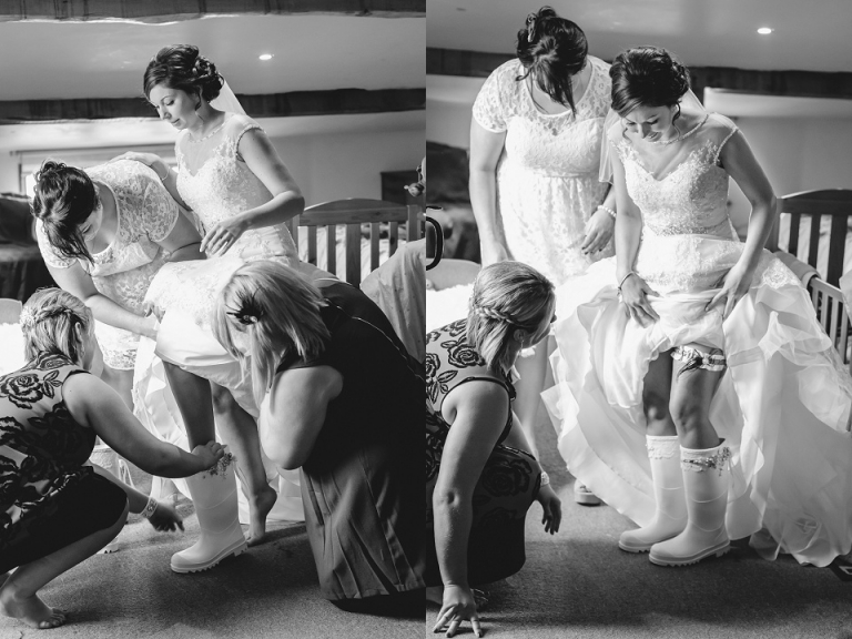 bride getting ready at dartmouth farm, putting on wellies and showing off garter in black and white