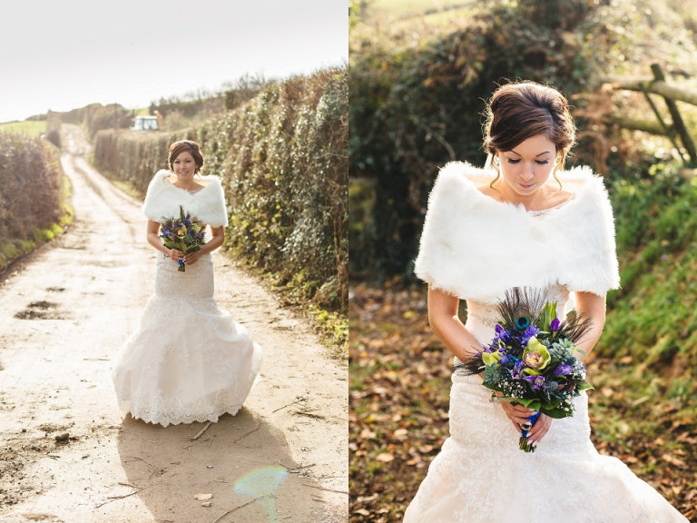 portrait of bride outside on farm on winter morning with sunrise, holding peacock bouquet