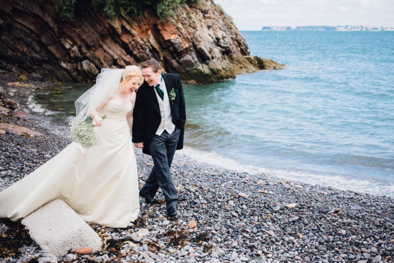 Best of wedding photography in Torquay, Paignton, London and Exeter - Natural, Candid, Photojournalistic couple portrait laughing on the beach by imperial hotel