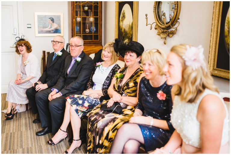 25 Small Intimate Cockington Court Wedding Photography in Torquay - guests lovingly watching ceremony