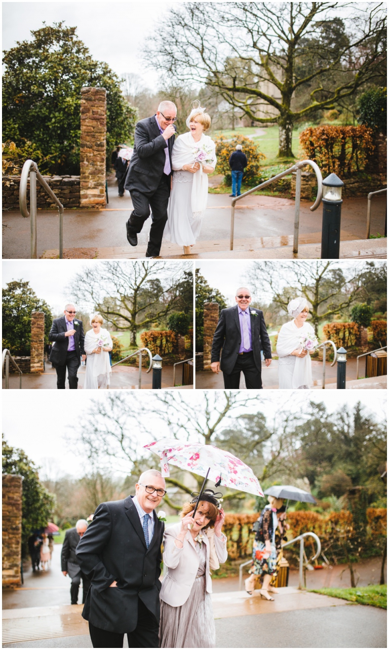 46 Small Intimate Cockington Court Wedding Photography in Torquay - guests laughing under umbrellas