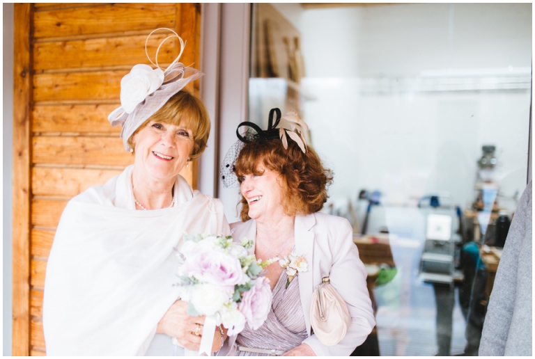 51 Small Intimate Cockington Court Wedding Photography in Torquay - bride laughing with sister, documentary style