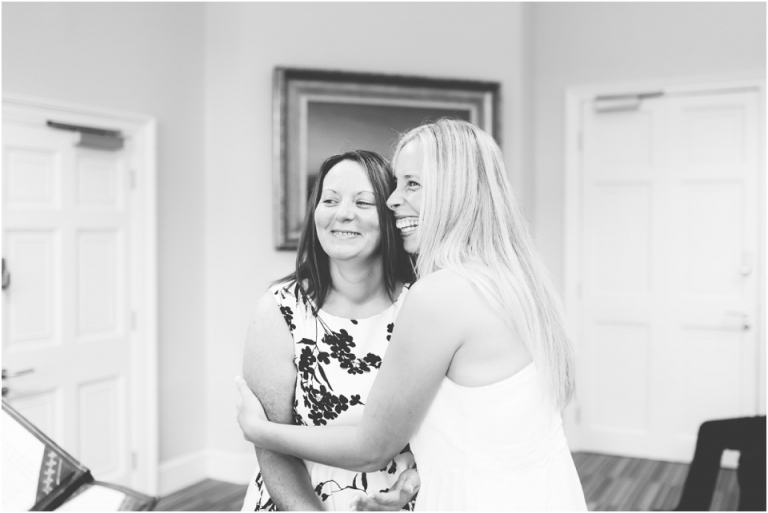 cockington-court-torquay-wedding-photography-documentary-style-7-black-and-white-brides-hugging-in-ceremony