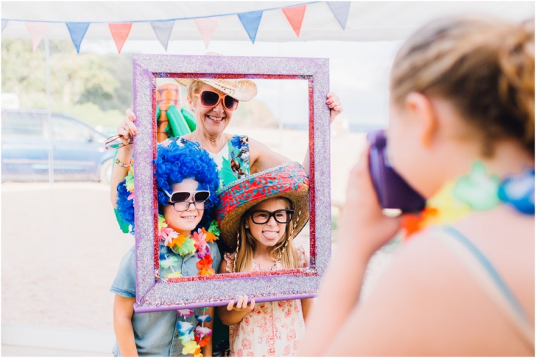 67 Blackpool Sands Dartmouth Wedding Photography Creative Documentary - guests using photo booth props
