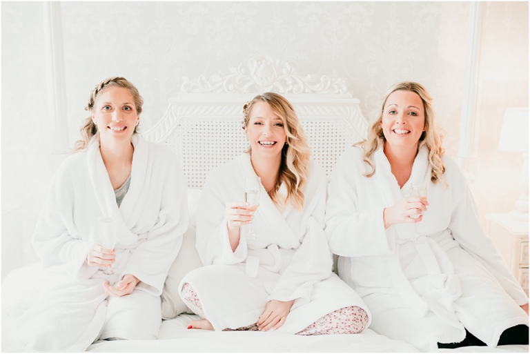 2 Relaxed, Fun, Colourful Wedding at Kingston Estate Devon Wedding Photography - bridesmaids on bed drinking champagne