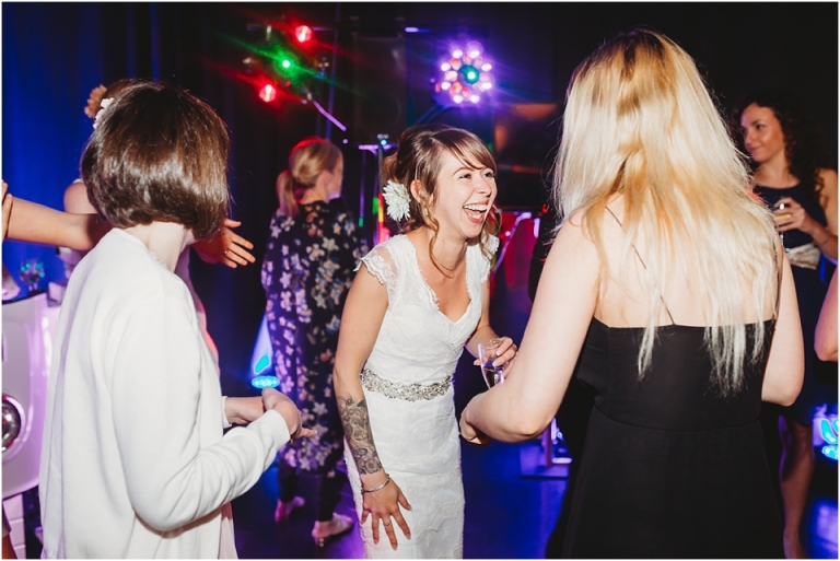 65 Wedding Reception Photography at The Flavel, Dartmouth - bride laughing on dance floor with friends