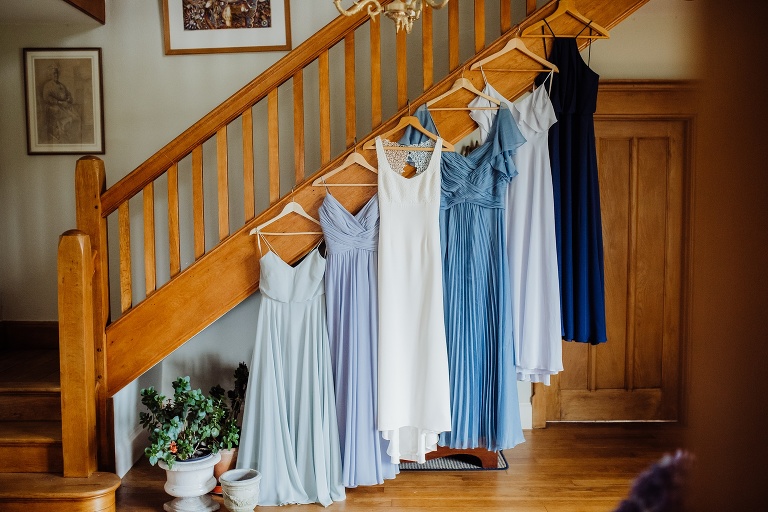 Chagford Church Marquee Wedding Photography Relaxed DIY Ceilidh Dance Celebration 16 Dresses hanging on staircase